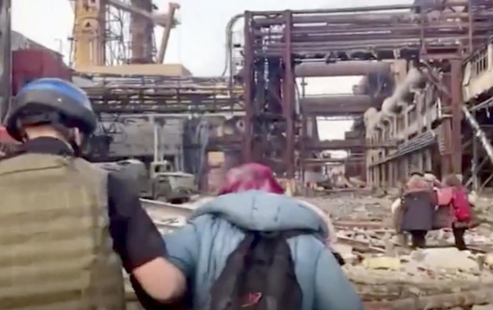 FILE - This image from an undated video provided by the Azov Special Forces Regiment of the Ukrainian National Guard on Sunday, May 1, 2022, shows people walking over debris at the Azovstal steel plant, in Mariupol, eastern Ukraine. The steel plant has a maze of more than 30 bunkers and tunnels spread out over its 11 square kilometers (4 miles), and each bunker was its own world. Evacuees had little or no communication with those elsewhere in the plant. (Azov Special Forces Regiment of the Ukrainian National Guard via AP, File)