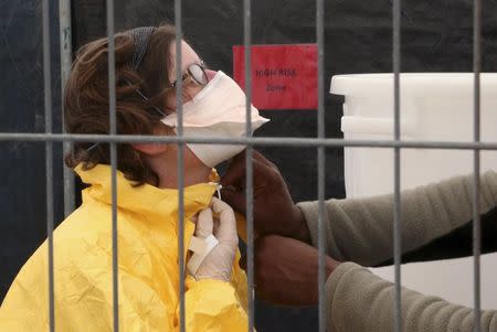 A volunteer for Medecins Sans Frontieres (MSF), or Doctors Without Borders, receives training on how to handle personal protective equipment during courses in Brussels October 15, 2014, which is aimed to help deal with the Ebola disease in West Africa. REUTERS/Francois Lenoir