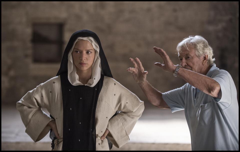 This image released by IFC Films shows Virginie Efira, left, with director Paul Verhoeven on the set of "Benedetta." (IFC Films via AP)