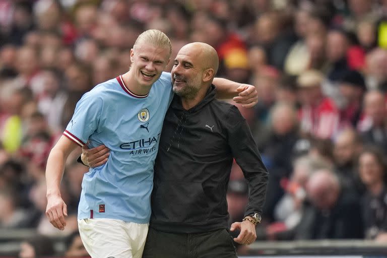 El técnico del Manchester City Pep Guardiola abraza a Erling Haaland durante las semifinales de la Copa FA ante el Sheffield United en el Estadio Wembley el sábado 22 de abril del 2023. (AP Foto/Alastair Grant)