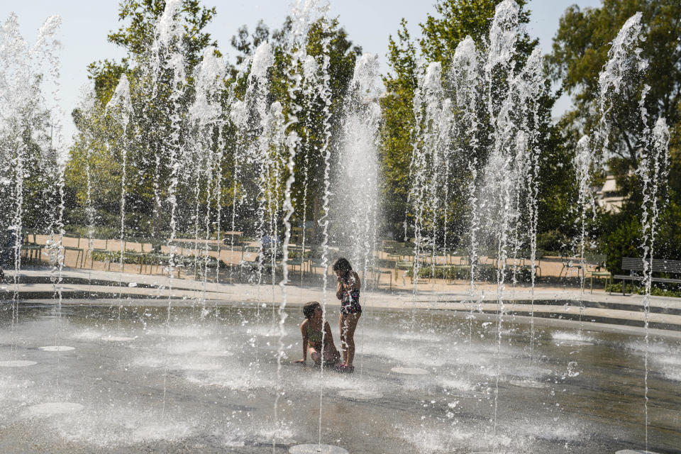 Children play in a water fountain during a heat wave, at Stavros Niarchos foundation Cultural Center in Athens, Thursday, July 13, 2023. Temperatures were starting to creep up in Greece, where a heatwave was forecast to reach up to 44 degrees Celsius in some parts of the country over the weekend. (AP Photo/Petros Giannakouris)