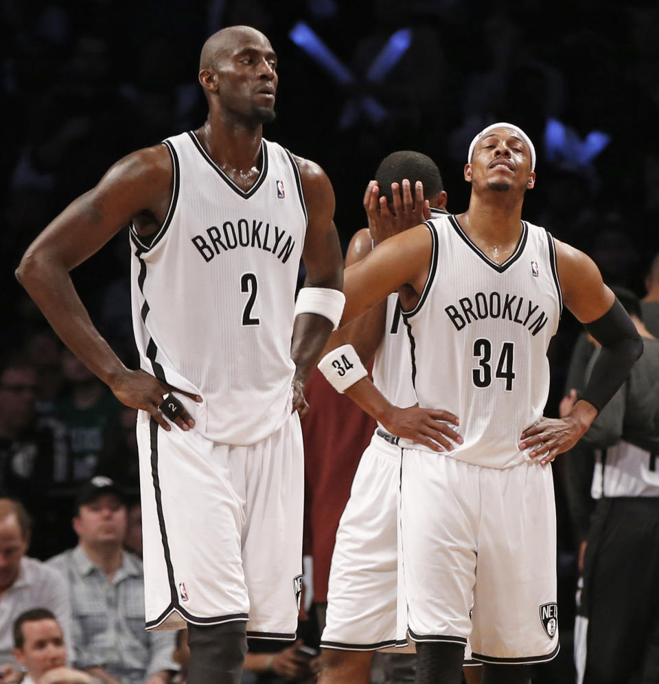 Kevin Garnett (2) y Paul Pierce (34), de los Nets de Brooklyn, esperan el final del cuarto partido de su serie de primera ronda de playoffs de la NBA ante los Raptors de Toronto en el Barclays Center, el domingo 27 de abril de 2014, en Nueva York. Los Raptors igualaron la serie 2-2 al vencer a los Nets 87-79. (Foto AP/Kathy Willens)