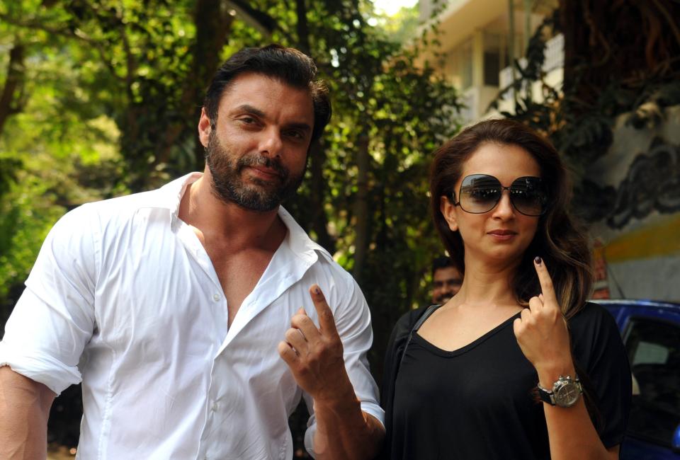 Indian Bollywood actor Sohail Khan (L) poses with his wife Seema Khan after voting in national elections at a polling station in Mumbai on April 24, 2014. India's 814-million-strong electorate is voting in the world's biggest election which is set to sweep the Hindu nationalist opposition to power at a time of low growth, anger about corruption and warnings about religious unrest.   AFP PHOTO/STR        (Photo credit should read STRDEL/AFP via Getty Images)