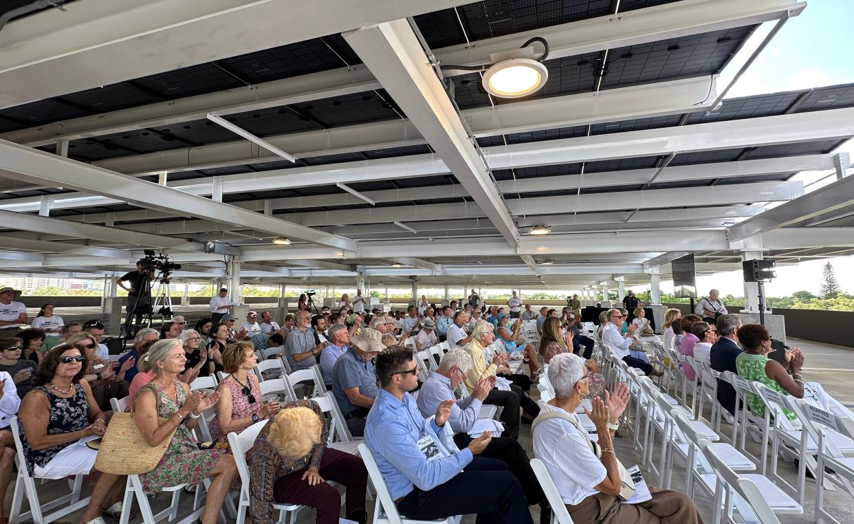 Guests at the Marie Selby Botanical Gardens' "Power On" ceremony Thursday morning, sit in the shade of 50,000 square-feet of solar panels on the fourth floor of the new parking garage.