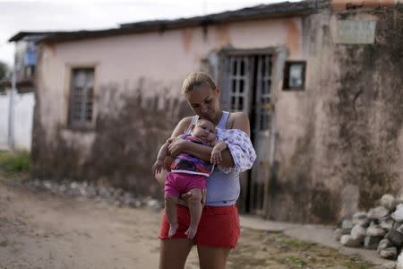 Gleyse Kelly da Silva holds her daughter Maria Giovanna, who has microcephaly, in front their house in Recife, Brazil, January 30, 2016. REUTERS/Ueslei Marcelino