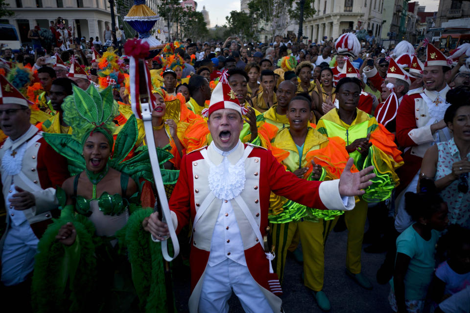 A member of Germany's "Rote Funken," center, dances with members of Cuba's famous carnival troupe "Guaracheros de Regla" as they hold a parade in Havana, Cuba, on Sunday, Sept. 30, 2018. Cologne, Germany's oldest carnival group traveled to Havana to show off their traditions with Cubans. (AP Photo/Ramon Espinosa)