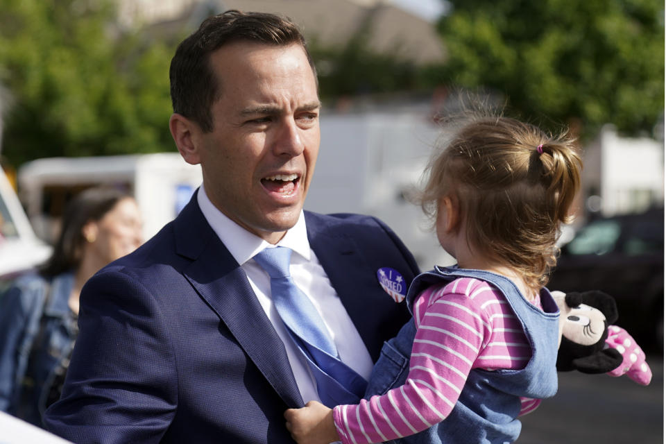 FILE — Rob Menendez, son of the current U.S. Sen. Bob Menendez, greets supporters while holding his daughter Olivia, 2, after voting in Jersey City, N.J., June 7, 2022. In northern New Jersey's 8th District, incumbent Democratic Rep. Rob Menendez — the senator's son — is seeking reelection against Hoboken Mayor Ravi Bhalla, who's tried to tie Rob Menendez to his father. (AP Photo/Seth Wenig, File)