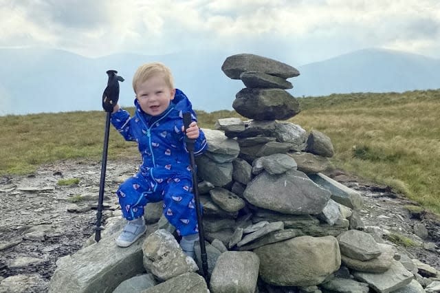 A baby was on top of the world as he tottered around a mountain summit