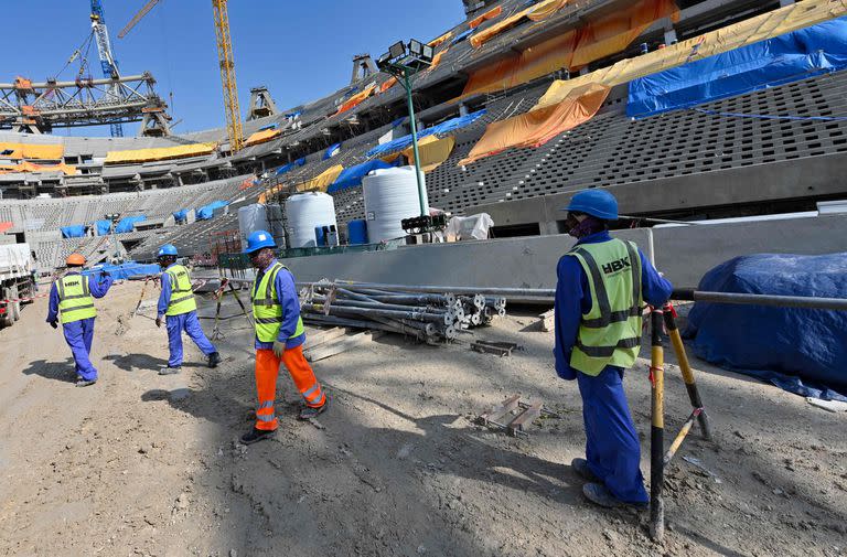 Esta foto de archivo tomada el 20 de diciembre de 2019,muestra a trabajadores de la construcción en el Estadio Lusail de Qatar, a unos 20 kilómetros al norte de la capital Doha.