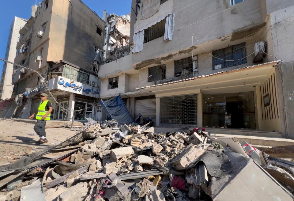 A municipality worker passes by debris of damaged buildings that were hit by an Israeli airstrike on Tuesday evening in the southern suburbs of Beirut, Lebanon (AP)