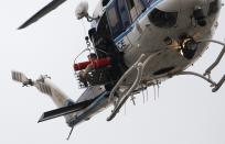 A police helicopter lifts what appears to be a shooting victim up as it hovers over a rooftop on the Washington Navy Yard campus in Washington, September 16, 2013. The U.S. Navy said several people were injured and there were possible fatalities in the shooting at the Navy Yard in Washington D.C. on Monday. The Navy did not immediately provide additional details but a Washington police spokesman said earlier that five people had been shot, including a District of Columbia police officer and one other law enforcement officer. (REUTERS/Jonathan Ernst)