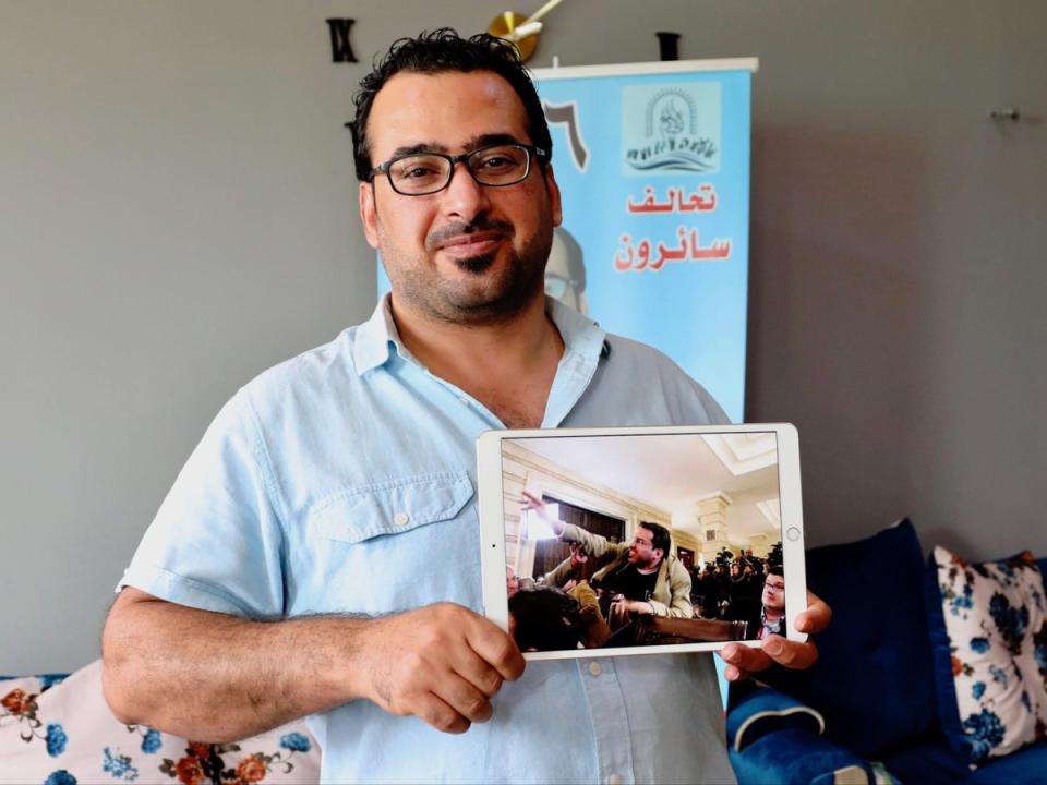 Muntadhar al Zaidi holding a photo of himself during the incident (Alamy)