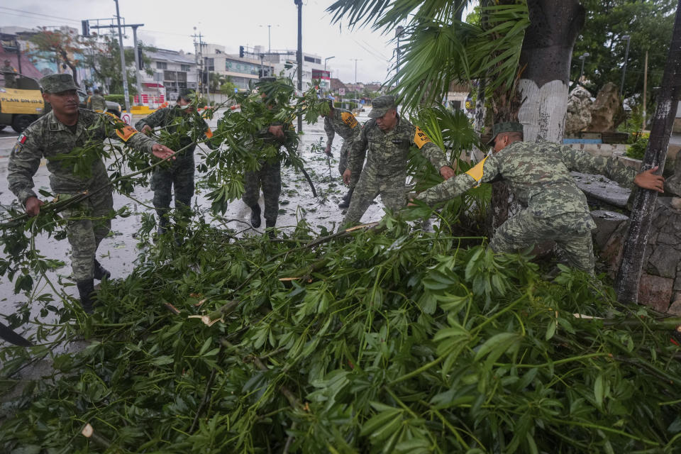 Soldados recogen ramas arrancadas por el huracán Beryl, el viernes 5 de julio de 2024, en Tulum, México. (AP Foto/Fernando Llano)