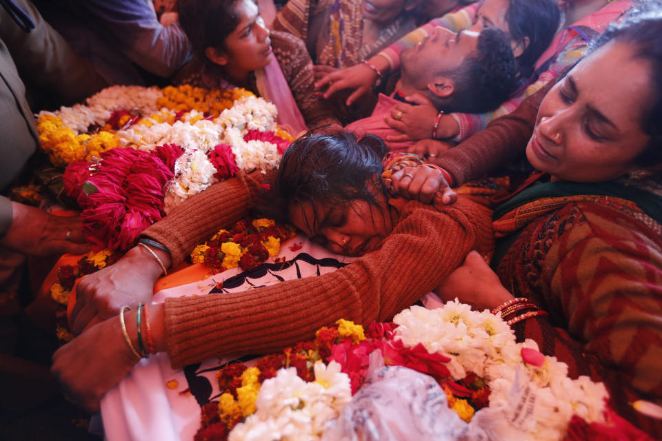 Sanjana cries over the body of her husband Mahesh Yadav, a Central Reserve Police Force (CRPF) soldier who was killed in Thursday bombing in Kashmir, in Tudihar village, some 56 kilometers east of Prayagraj, Uttar Pradesh state, India, Saturday, Feb. 16, 2019. As India considers its response to the suicide car bombing of a paramilitary convoy in Kashmir that killed dozens of soldiers, a retired military commander who oversaw a much-lauded military strike against neighboring Pakistan in 2016 has urged caution. (AP Photo/ Rajesh Kumar Singh)