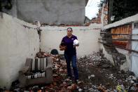 <p>Maria Trinidad Gonzalez, 41, a housewife, holds some cookware as she poses for a portrait on the rubble of her house after an earthquake in Tepalcingo, Mexico, September 29, 2017. The house was badly damaged, but with the help of her family and soldiers Gonzalez rescued some furniture. She lives in her backyard and hopes to return home once it’s rebuilt. “The most valuable thing that I recovered was my cookware,” Gonzalez said. (Photo: Edgard Garrido/Reuters) </p>