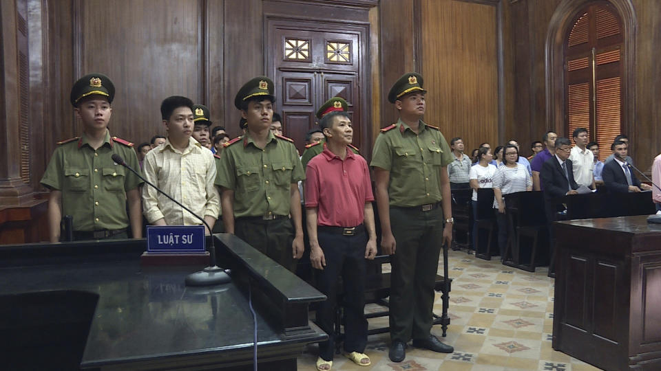 Michael Nguyen, center, stands during his trial, Monday, June 24, 2019, in Ho Chin Minh City, Vietnam. The American of Vietnamese origin was sentenced to 12 years in prison for "attempt to overthrow the state." (Nguyen Thanh Chung/Vietnam News Agency via AP)