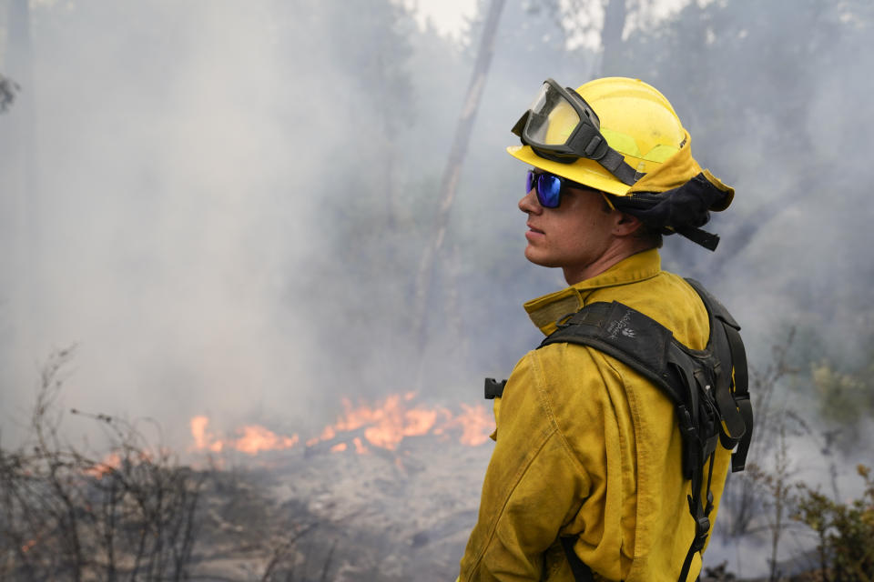 Firefighter Cody Nordstrom, of the North Central Fire station out of Kerman, Calif., monitors hot spots while fighting the CZU Lightning Complex Fire on Sunday, Aug. 23, 2020, in Bonny Doon, Calif. (AP Photo/Marcio Jose Sanchez)