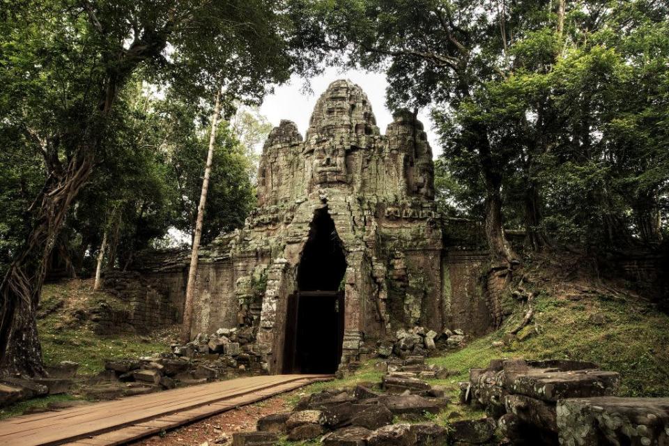 The East gate of Angkor Thom, featuring a giant face, at the famous temple area of Angkor Archeological Park in Siem Reap, Cambodia. Literally meaning 'Great City' in Khmer, it covers an area of 9 square kilometres.