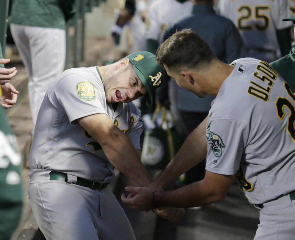 Oakland Athletics' Josh Phegley, left, and Matt Olson joke in the dugout before a baseball game against the Seattle Mariners, Monday, Sept. 24, 2018, in Seattle. (AP Photo/John Froschauer)