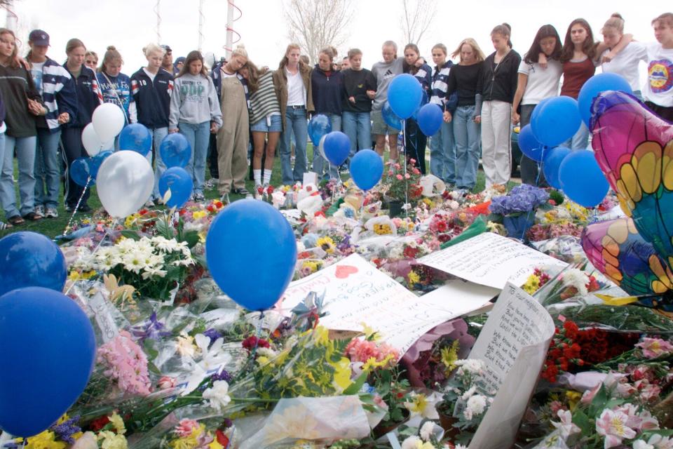 Students stand with arms around each other at an impromptu memorial to students killed at Columbine High School on April 21, 1999.