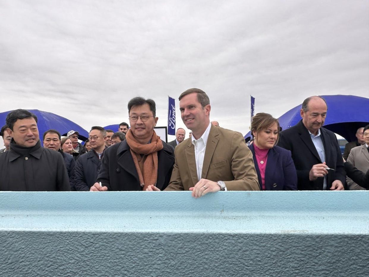 Gov. Andy Beshear and BlueOval SK CEO, David Hahm signed a beam outside the construction site of BlueOval SK, a battery production plan located in Glendale, Kentucky.