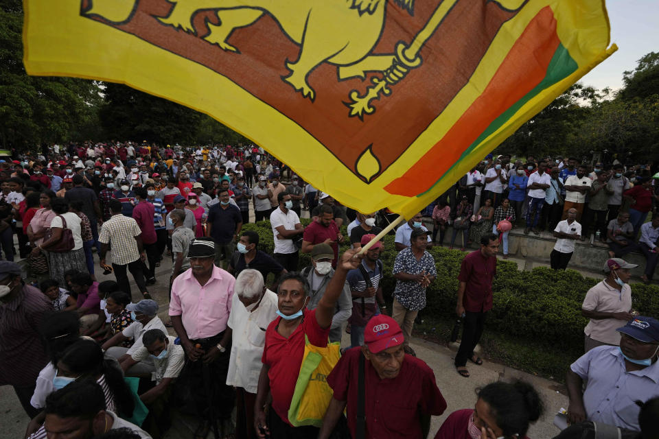 A member of Sri Lanka's opposition political party National People's Power waves country's national flag as he participates in an anti-government protest rally in Colombo, Sri Lanka, Tuesday, April 19, 2022. Sri Lanka’s prime minister said Tuesday the constitution will be changed to clip presidential powers and empower Parliament as protesters continued to call on the president and his powerful family to quit over the country's economic crisis. (AP Photo/Eranga Jayawardena)