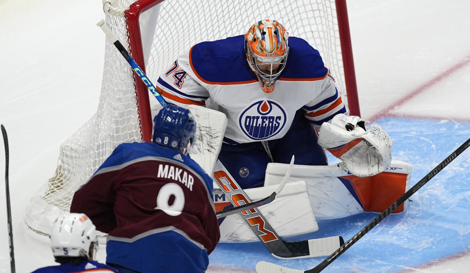 Edmonton Oilers goaltender Stuart Skinner stops a shot by Colorado Avalanche defenseman Cale Makar during the first period of an NHL hockey game Thursday, April 18, 2024, in Denver. (AP Photo/David Zalubowski)