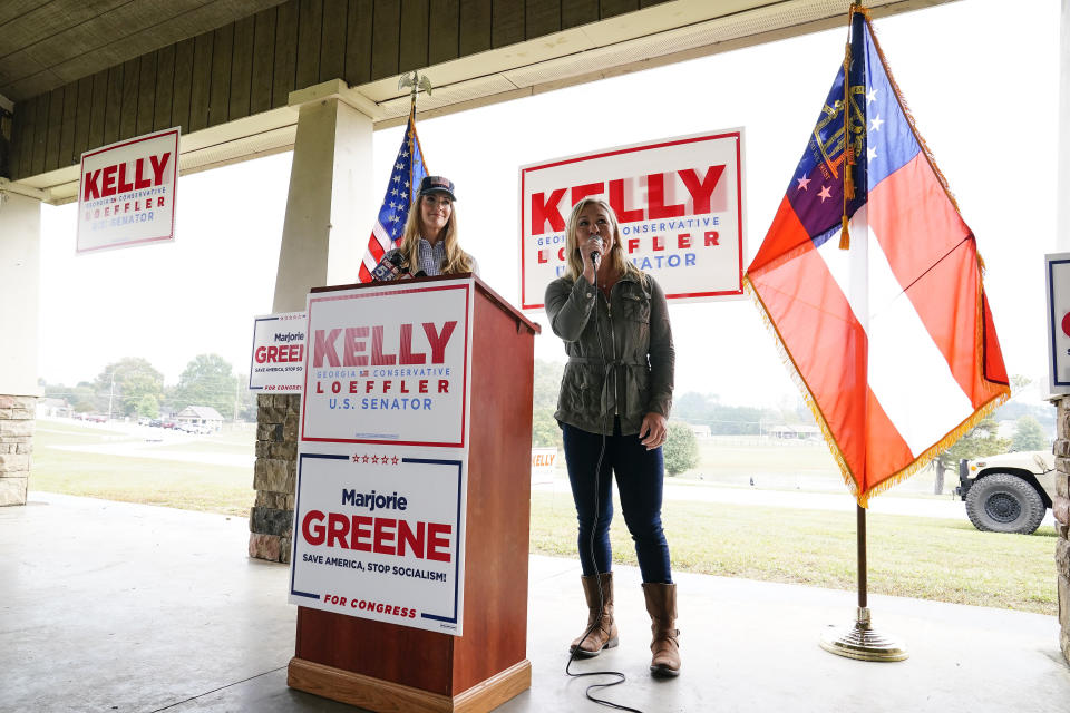 Republican congressional candidate Marjorie Taylor Greene, right, speaks as Sen. Kelly Loeffler, R-Ga., listens during a news conference on Thursday, Oct. 15, 2020, in Dallas, Ga. (AP Photo/Brynn Anderson)