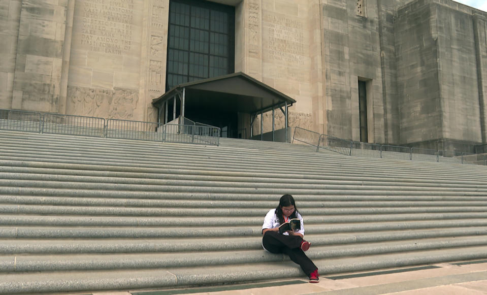 Arielle Leighton, 13, reads on the Louisiana Capitol steps in Baton Rouge, La., on Tuesday, April 16, 2024. The eighth grader, who is a transgender girl, visited the state building with her Dad to oppose bills targeting the state’s LGBTQ+ community. (AP Photo/Stephen Smith)