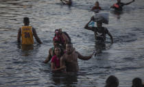 Migrants wade across the Rio Grande from Del Rio, Texas, to Ciudad Acuña, Mexico, Sunday, Sept. 19, 2021. (AP Photo/Felix Marquez)