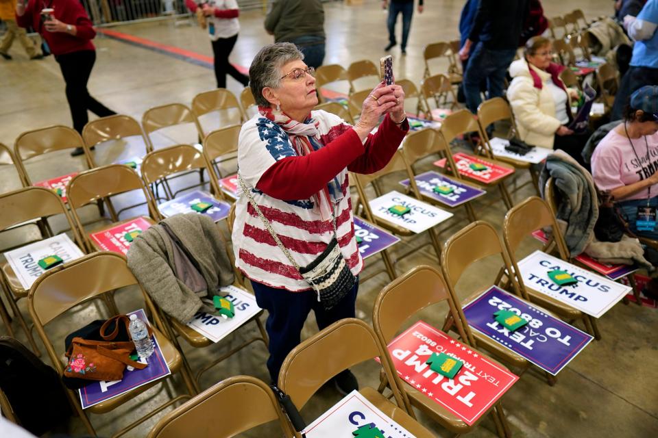 Ardith Barnes, of Clermont, Iowa, takes a photos as she waits for former President Donald Trump to arrive at a commit to caucus rally, Friday, Jan. 5, 2024, in Mason City, Iowa. (AP Photo/Charlie Neibergall)