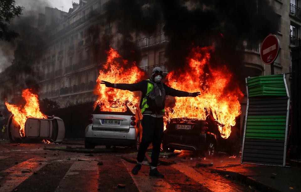 Protesters wearing yellow vests set cars and barricades on fire as they clash with riot police on Avenue Foch near the Arc de Triomphe during a demonstration over high fuel prices in Paris, Dec. 1,2018. (Photo: Etienne Laurant/EPA-EFE/REX/Shutterstock)