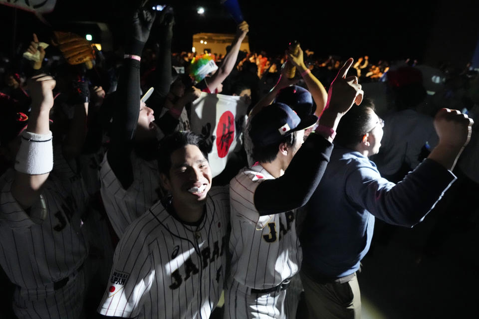People celebrate Japan's victory against United States as they watch on a live stream of a World Baseball Classic (WBC) final being played at LoanDepot Park in Miami, during a public viewing event Wednesday, March 22, 2023, in Tokyo. (AP Photo/Eugene Hoshiko)