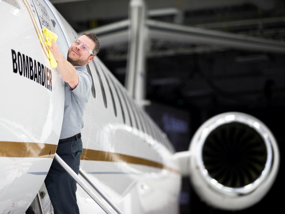 FILE PHOTO: Bombardier employee Francis Masse polishes the sign of Bombardier's Global 7500, the first business jet to have a queen-sized bed and hot shower, is shown during a media tour in Montreal, Quebec, Canada, December 19, 2018. REUTERS/Christinne Muschi