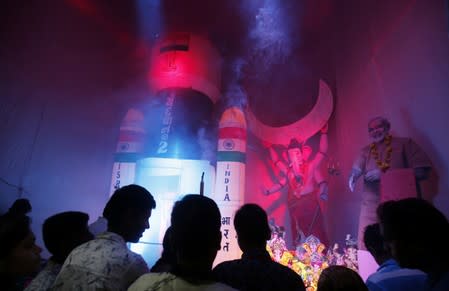 Devotees worship an idol of the Hindu god Ganesh, the deity of prosperity, as a model of India's Geosynchronous Satellite Launch Vehicle Mk III-M1, which carried Chandrayaan-2, is seen next to the it, inside a "pandal" or makeshift stage, on the fifth day