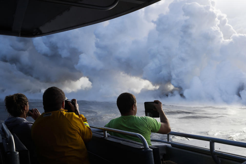 Diese Selfie-Touristen sollten auf jeden Fall Gasmasken tragen: Wenn die Lava auf Wasser trifft, entsteht die giftige „Laze“-Rauchwolke. (Bild: AP Photo/Jae C. Hong)