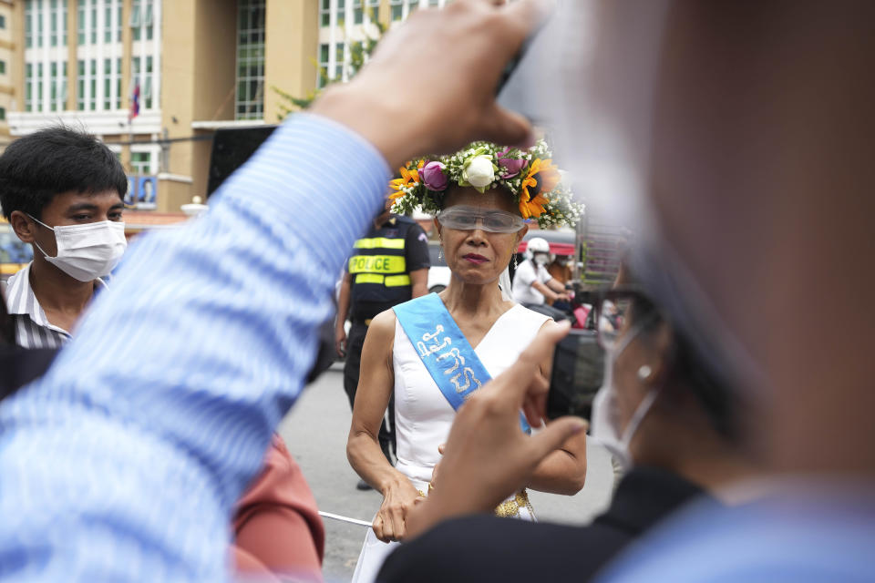 Cambodian-American lawyer Theary Seng, dressed in a pageant costume that reads "Lady Justice", talks to media outside Phnom Penh Municipal Court in Phnom Penh, Cambodia, Tuesday, May 3, 2022. Tuesday is the the final day of hearings for her trial on treason and a related charge for which she could receive a prison sentence of up to 12 years. (AP Photo/Heng Sinith)