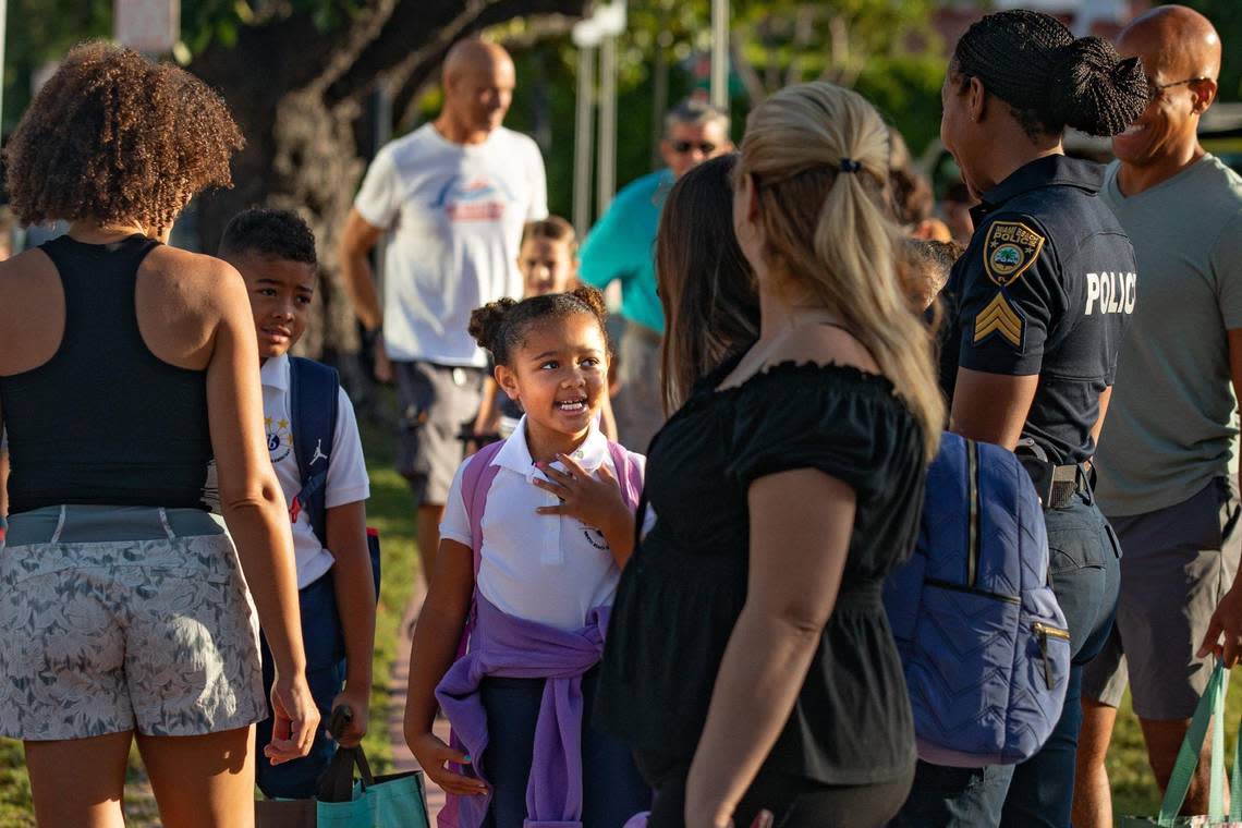 Students and parents wait to cross Prairie Avenue to enter North Beach Elementary in Miami Beach, Florida on the first day of school Aug. 17, 2022.