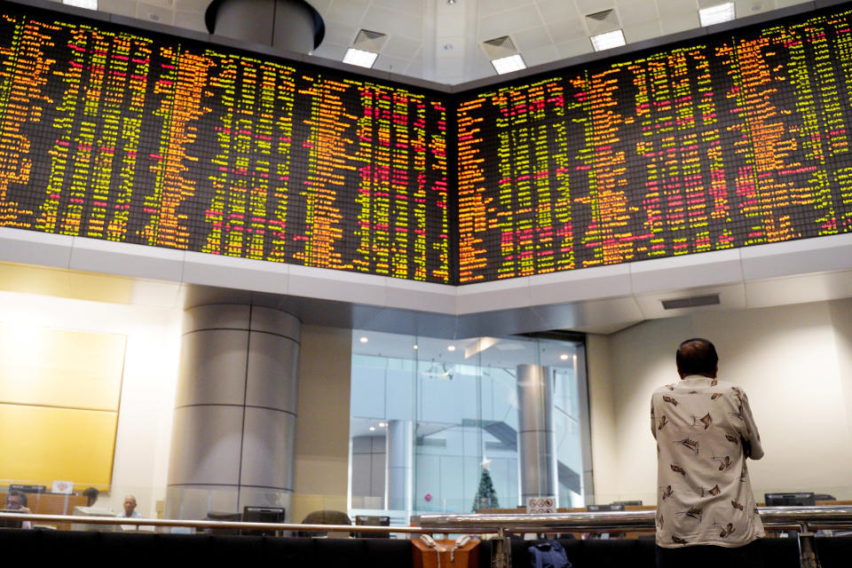 A visitor stands in front of private stock trading boards at a private stock market gallery in Kuala Lumpur, Malaysia, Friday, Dec. 7, 2018. Asian shares were mostly higher Friday after gains on Wall Street but investors continued to watch for news about U.S.-China trade friction. (AP Photo/Yam G-Jun)