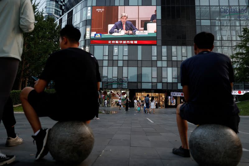 Giant screen shows news footage of U.S. Special Presidential Envoy for Climate John Kerry attending a meeting with Chinese Vice Premier Han Zheng, in Beijing