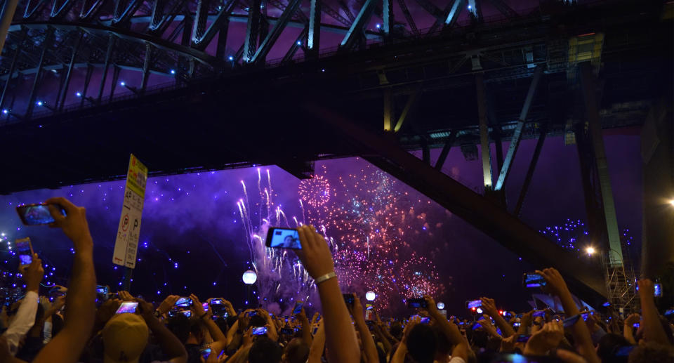 people gathered watching New Year's Eve fireworks last year in Sydney