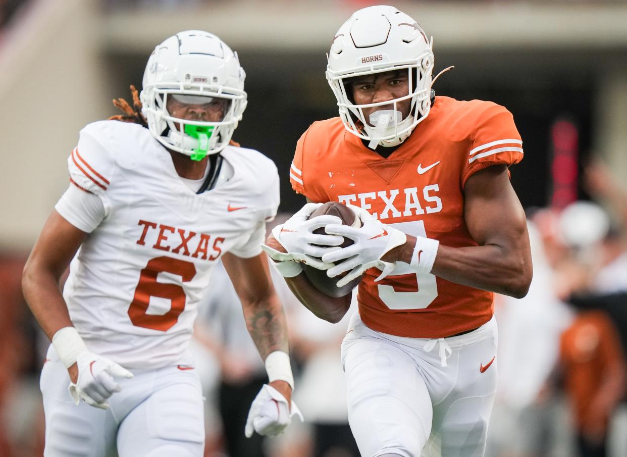Texas wide receiver Ryan Wingo, right, tries to pull away from cornerback Kobe Black in Saturday's Orange-White game at Royal-Memorial Stadium. Wingo, a freshman, capped an impressive spring with a strong showing in the scrimmage.