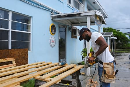 A man constructs storm shutters before the arrival of Hurricane Dorian in Marsh Harbour