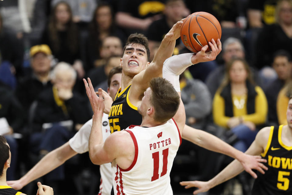 Iowa center Luka Garza blocks a shot by Wisconsin forward Micah Potter (11) during the first half of an NCAA college basketball game, Monday, Jan. 27, 2020, in Iowa City, Iowa. (AP Photo/Charlie Neibergall)