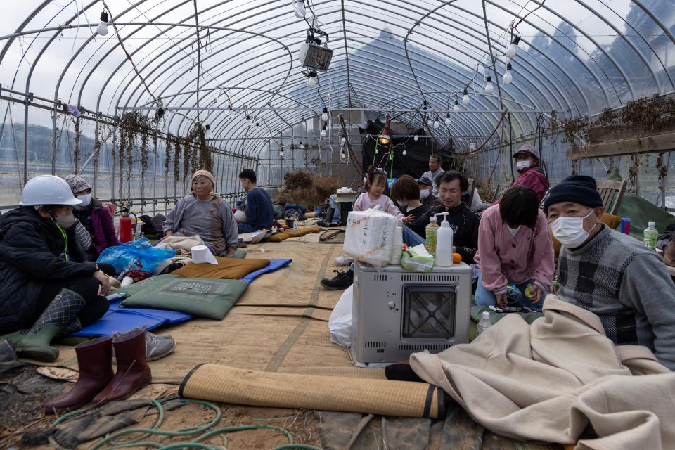 Local residents sit on the ground while sheltering for safety at a greenhouse on January 02, 2024 in Wajima, Japan. A series of major earthquakes have reportedly killed at least 55 people, injured dozens more and destroyed a large amount of homes. The earthquakes, the biggest measuring 7.1 magnitude, hit the areas around Toyama and Niigata in central Japan on Monday.