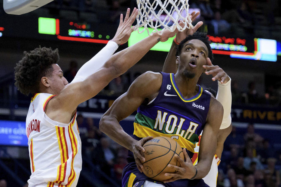 New Orleans Pelicans forward Herbert Jones goes to the basket as Atlanta Hawks forwards Jalen Johnson (1) and Onyeka Okongwu defend during the first half of an NBA basketball game in New Orleans, Tuesday, Feb. 7, 2023. (AP Photo/Matthew Hinton)