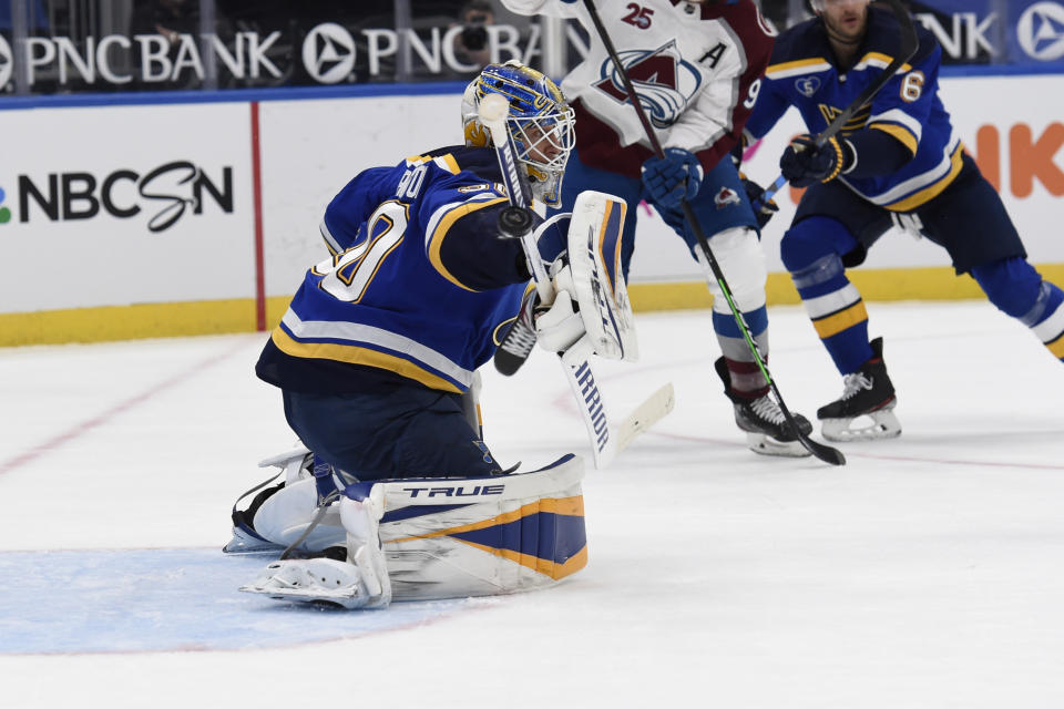 St. Louis Blues' Jordan Binnington (50) blocks a shot from the Colorado Avalanche during the first period of an NHL hockey game on Wednesday, April 14, 2021, in St. Louis. (AP Photo/Joe Puetz)