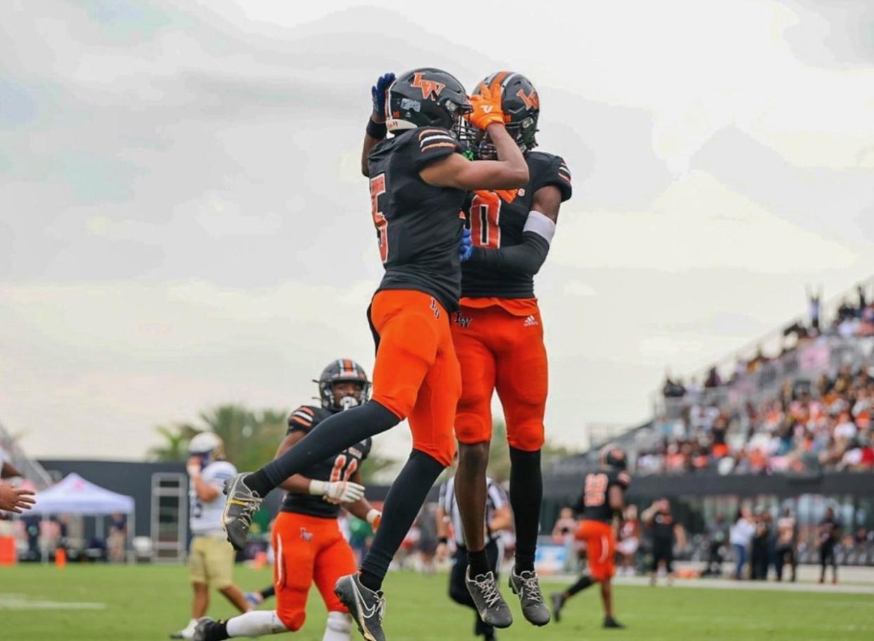 Lake Wales' Philipp Davis celebrates with teammate Jaremiah Anglin Jr. in a Class 3S state championship after he picked off his second pass of the day. Lake Wales won the championship 32-30 over Mainland.