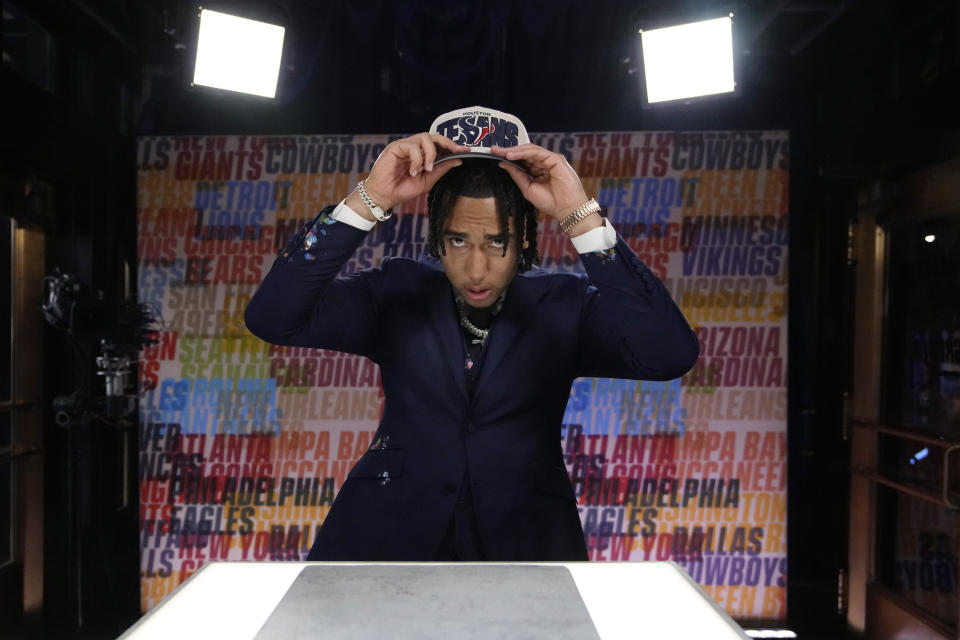 Ohio State quarterback C.J. Stroud puts on a hat after being chosen by the Houston Texans with the second overall pick during the first round of the NFL football draft, Thursday, April 27, 2023, in Kansas City, Mo. (AP Photo/John Locher)