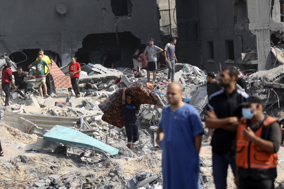 Palestinians walk among debris of buildings that were targeted by Israeli airstrikes in Jabaliya refugee camp, northern Gaza Strip, Wednesday, Nov. 1, 2023. (AP Photo/Abed Khaled)